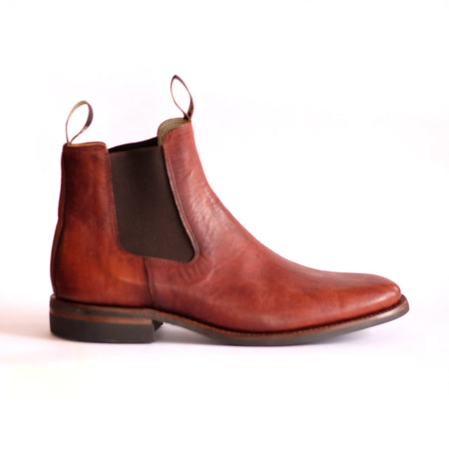Side view of brown leather Chelsea boot on a white background 